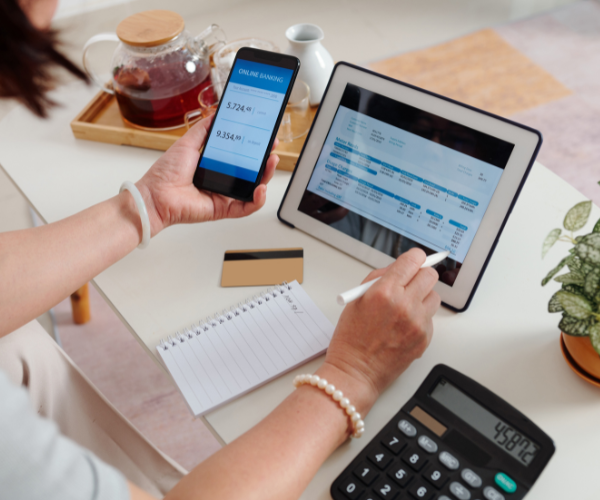 Person doing bookkeeping on mobile and tablet